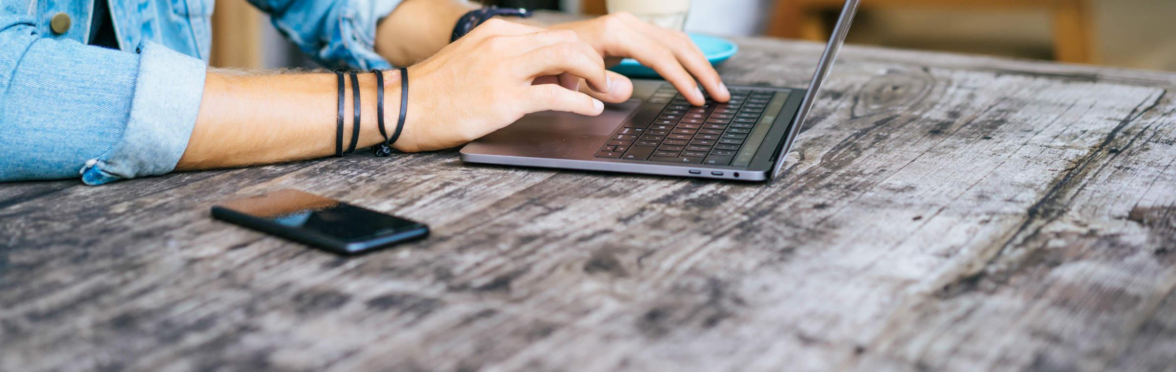 Un jeune homme navigue sur internet depuis son ordinateur portable